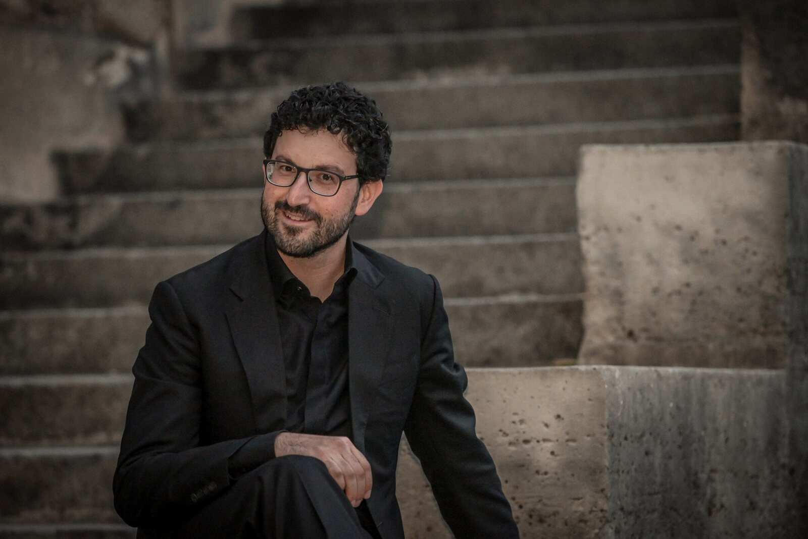 Ben Kazez seated on stone steps